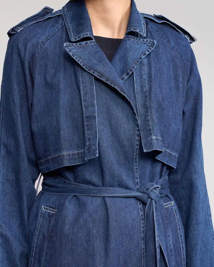 Blue denim trench coat on a neutral background