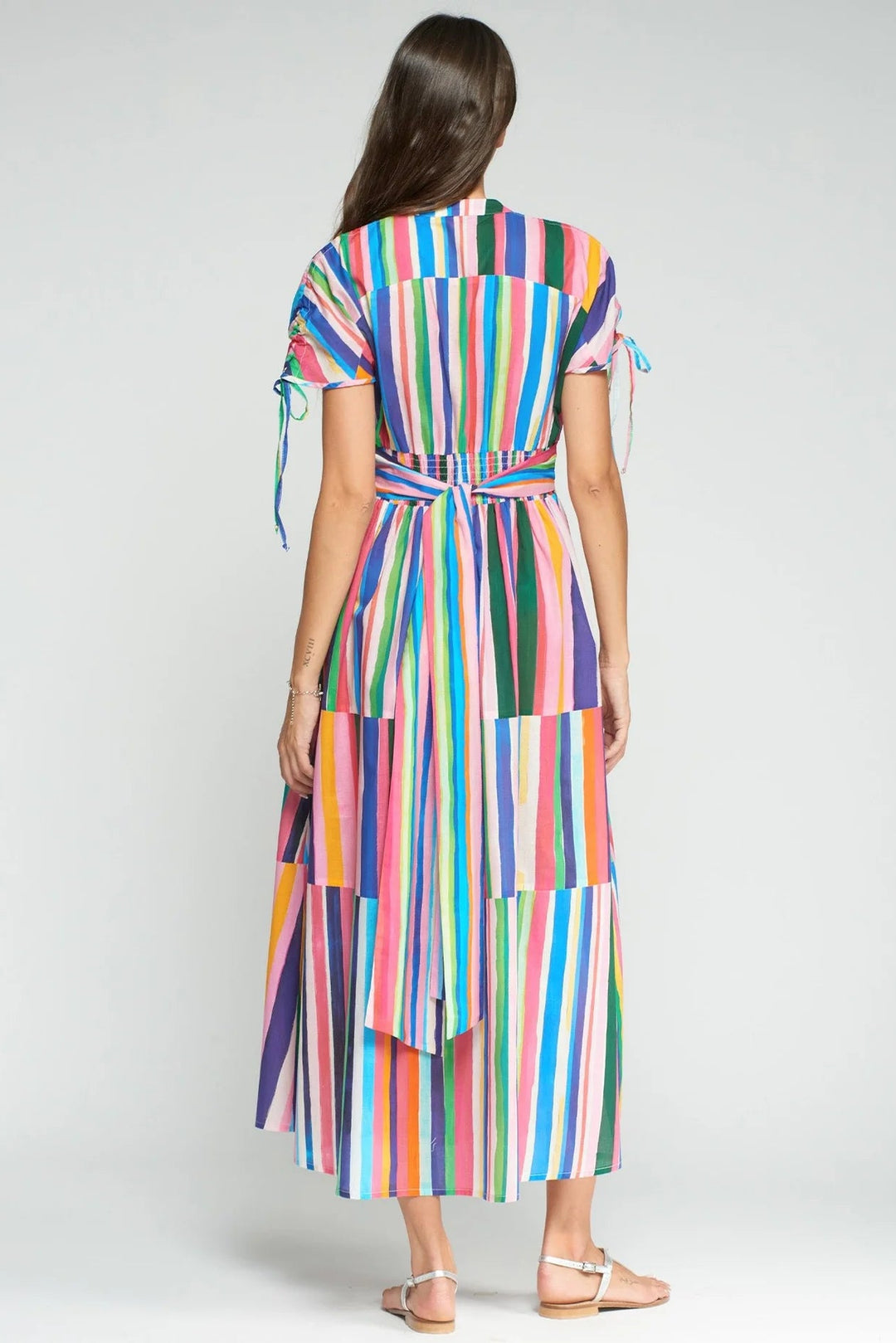 Woman wearing a colorful striped dress on a white background
