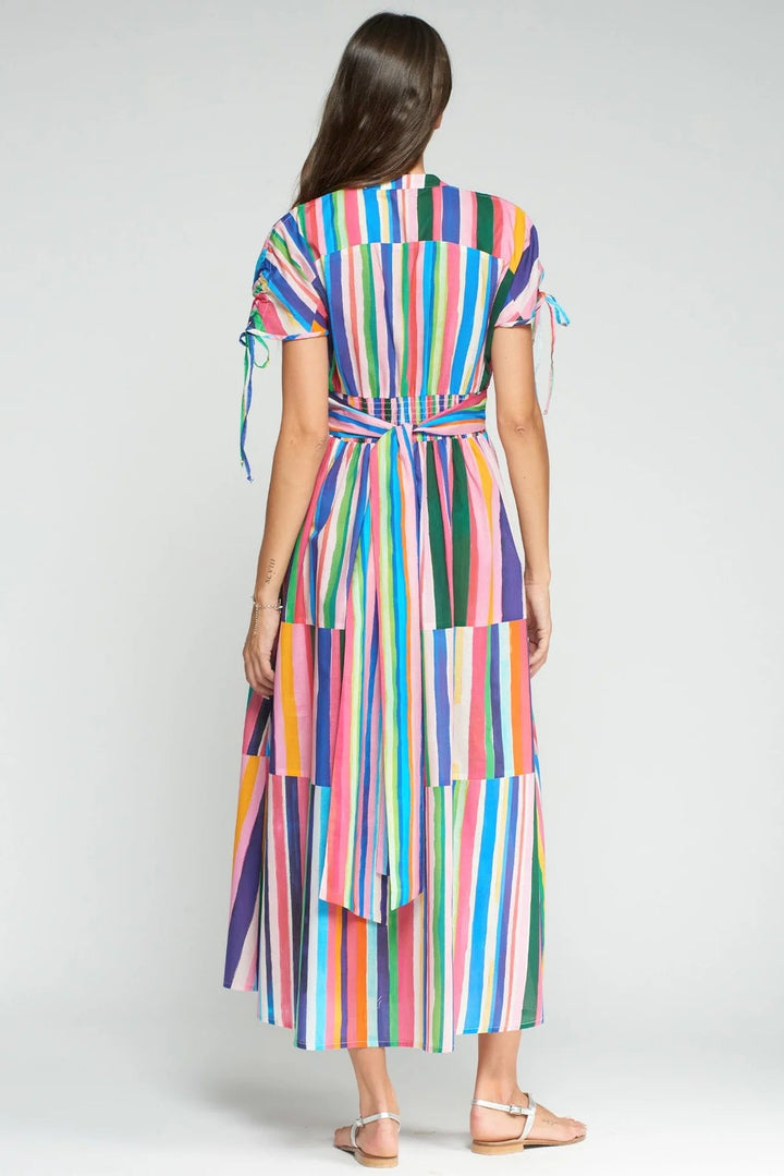 Woman wearing a colorful striped dress on a white background