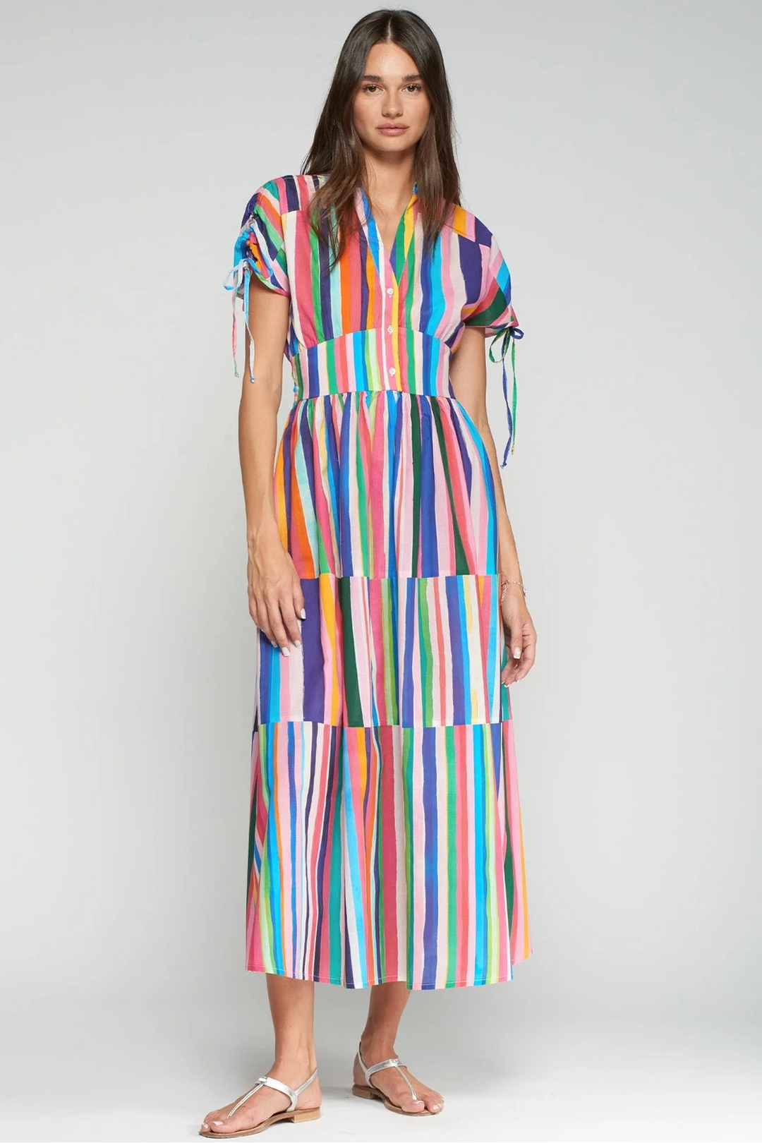 Woman wearing a colorful striped dress on a white background