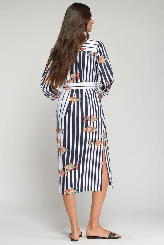 Woman wearing a black and white striped dress with floral patterns on a plain background