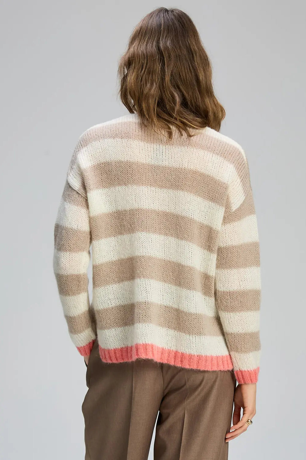 Person wearing a striped sweater with a neutral background