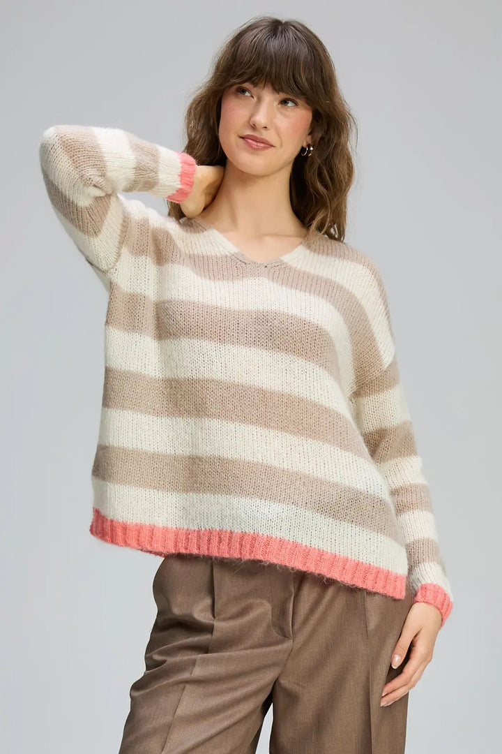 Woman wearing a striped sweater with a neutral background