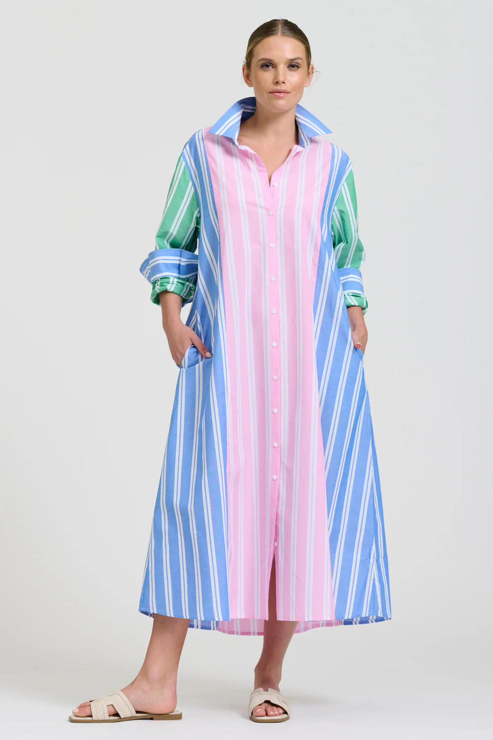 Woman wearing a colorful striped dress on a white background