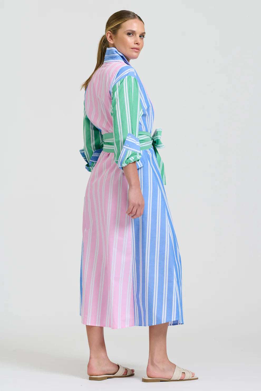 Woman wearing a colorful striped dress on a white background