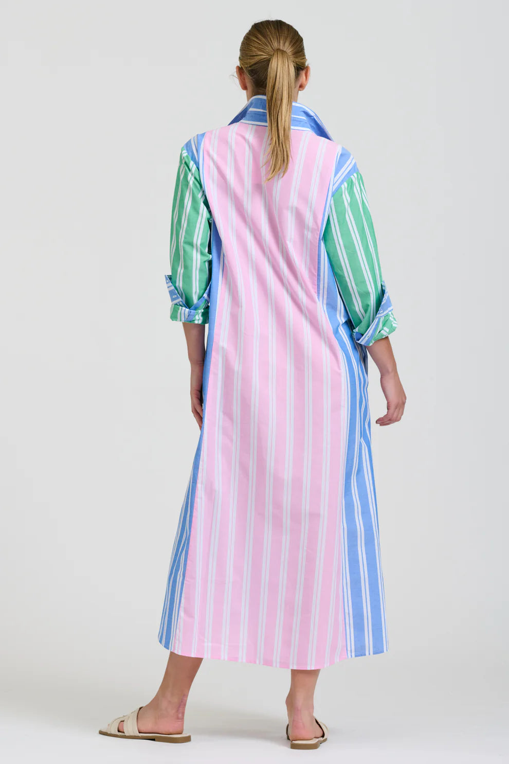 Woman wearing a colorful striped dress with a white background