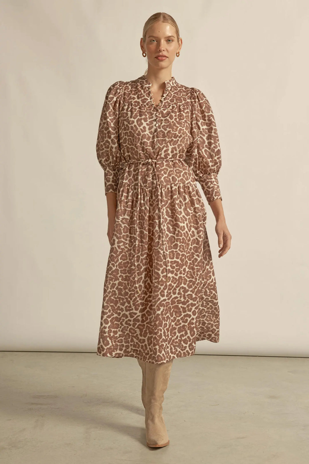 Woman wearing a patterned dress against a plain background