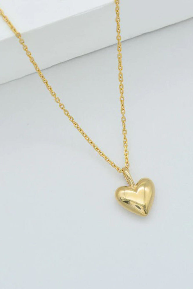 A gold-colored, heart-shaped pendant on a cable chain necklace.